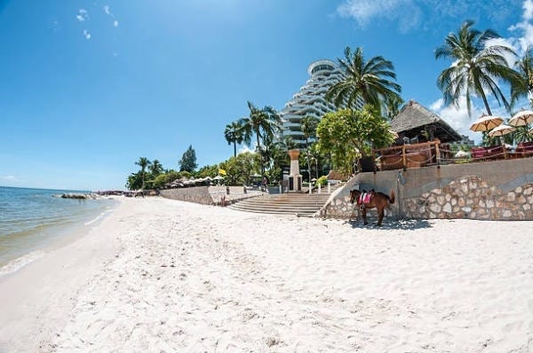 Considering the image of ‘a beach at or near the apartment’ and the location being ‘Hua Hin,’ an appropriate alt text could be ‘Idyllic seaside near Hua Hin apartment.’