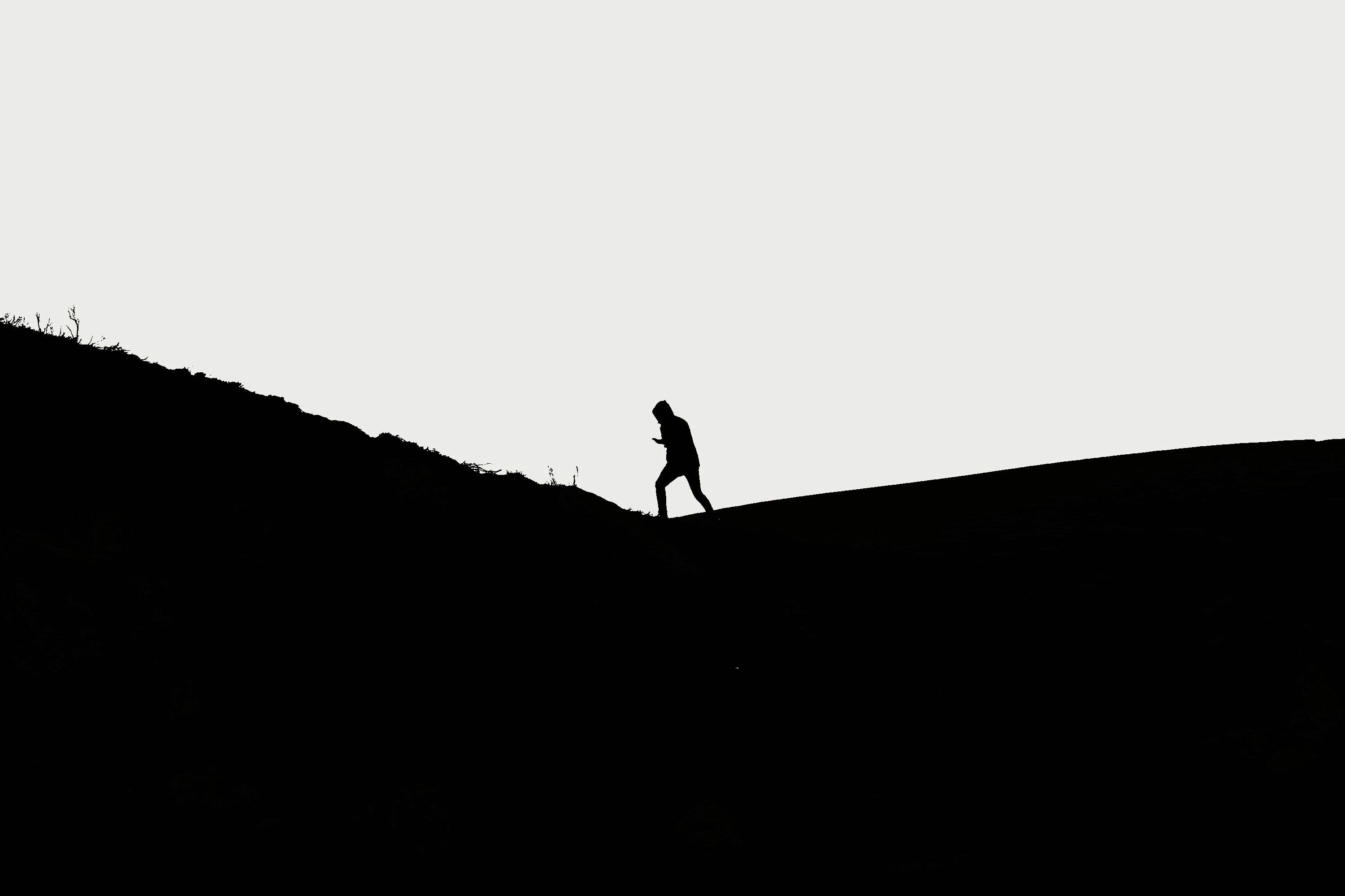 산등성이를 따라 혼자 걷는 남자의 흑백 이미지입니다.<BR>