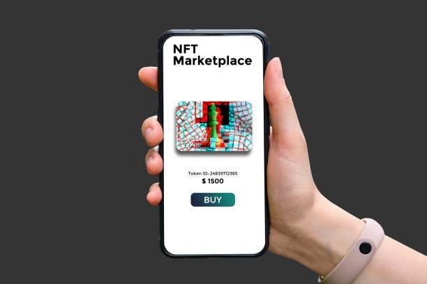 This image shows of a hand holding a mobile phone which reads NFT marketplace, an NFT image, token ID, price and a buy button