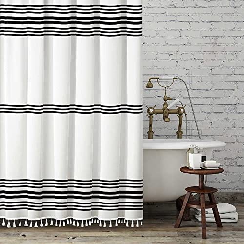 Monochrome shower curtain hanging in a bathroom with a white tub.