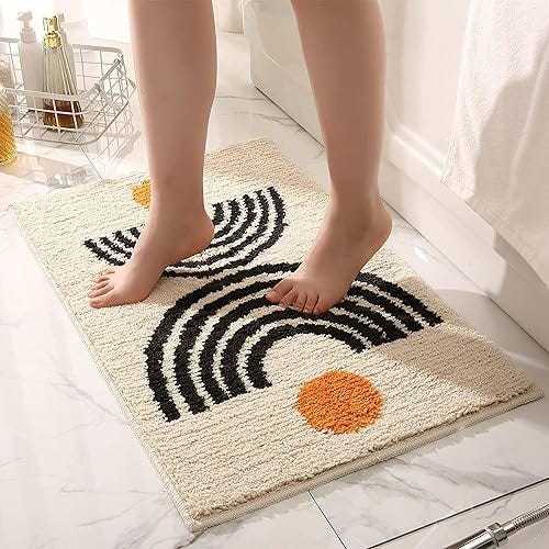 A person standing on a black and white bath mat, adding a stylish touch to the bathroom decor.