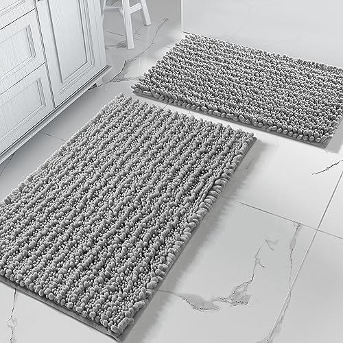 Two bath mats in blue and gray on a white floor.