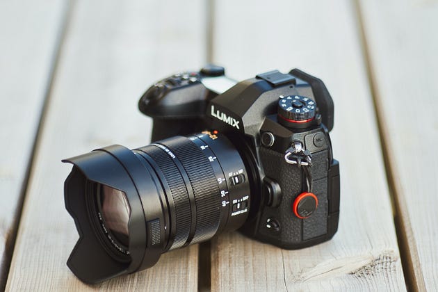 a digital camera on a wooden bench
