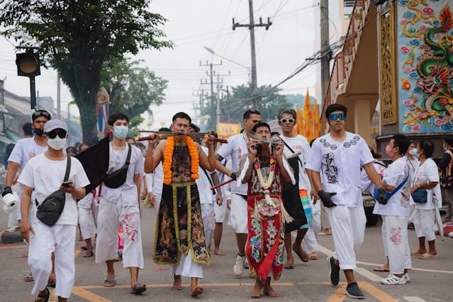 Festival goers parade down the street during the Vegetarian Festival in Phuket. Photo by Maksim Romashkin via Pexels.