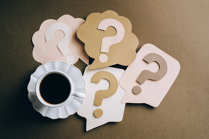 Question marks around a cup of coffe