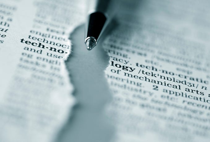 Page of a dictionary, ripped off into half on the word of Technology