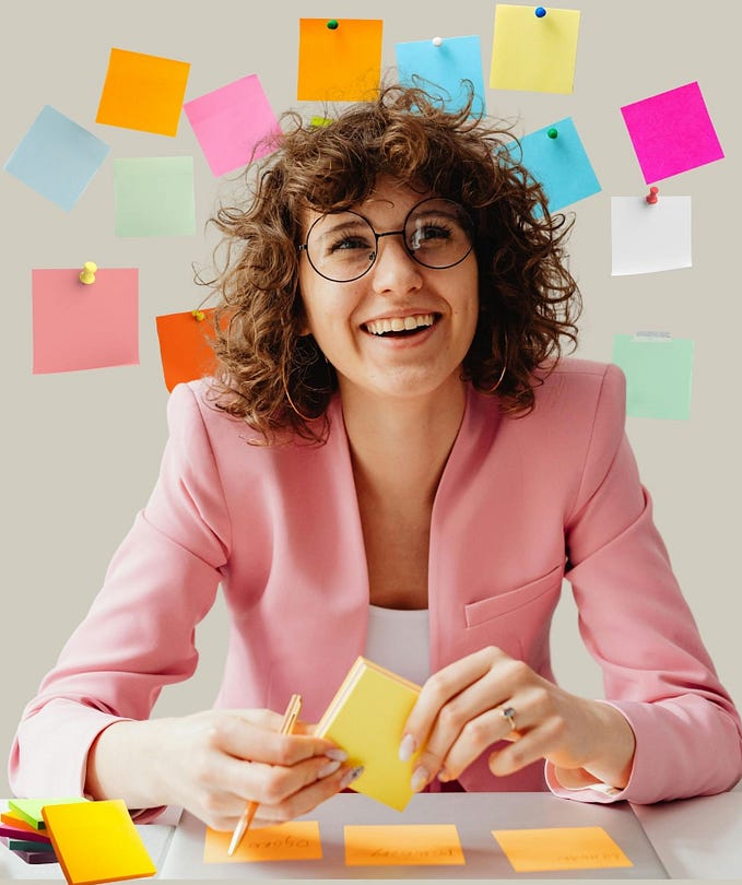 women sitting at a desk surrounded by sticky notes