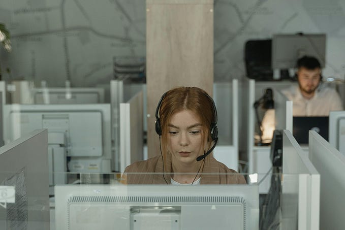 A woman at a call center, talking with customers on a headset