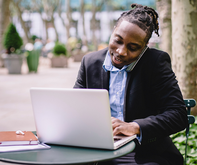 African man making calls and managing transactions on phone. Tulix wants to make the remittance experience better for Africa