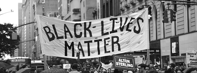 Black Lives Matter protests holding up a “Black Lives Matter” banner in Manhattan