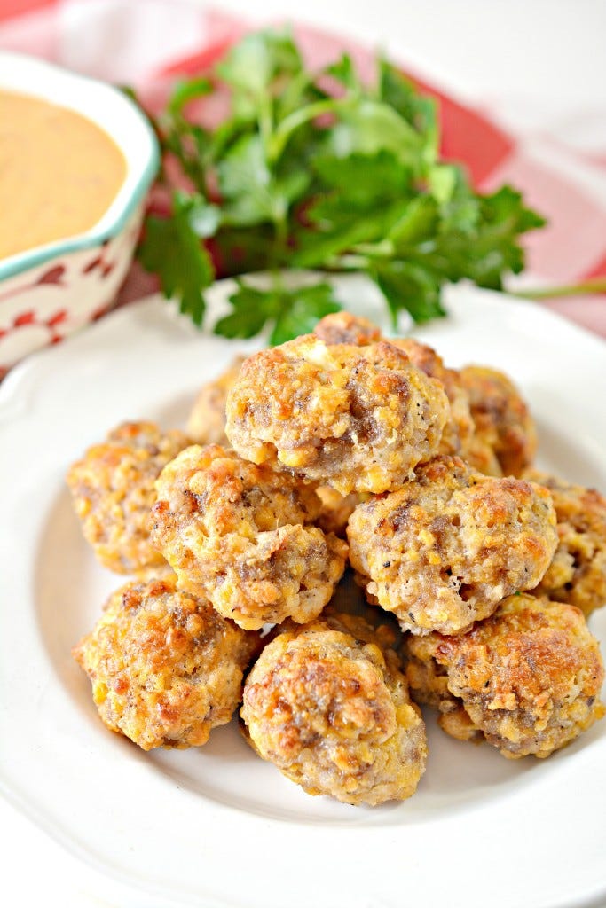 KETO CREAM CHEESE SAUSAGE BALLS SERVEN OVER A PLATE STACKED ABOVE EACH OTHER