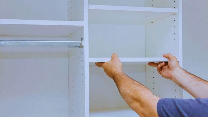 Man Adjusting White Custom Closet