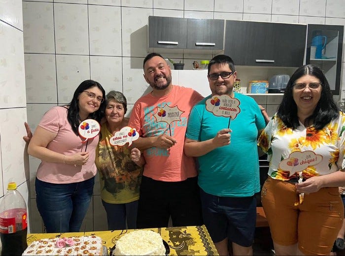Alex (de azul) em um aniversário com sua família. Sua irmã Giselle (canto direito), sua mãe Maria Odete (à direita), seu irmão Ariston (ao centro) e sua irmã Susi (à esquerda). (Ano: 2019/Acervo pessoal)