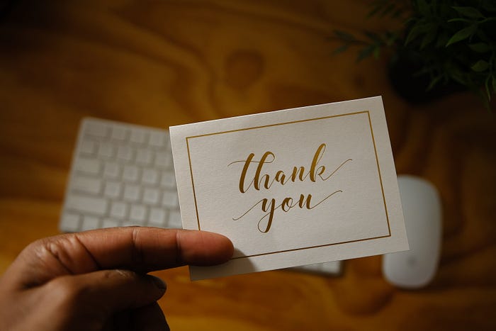 hand holding a thank you card