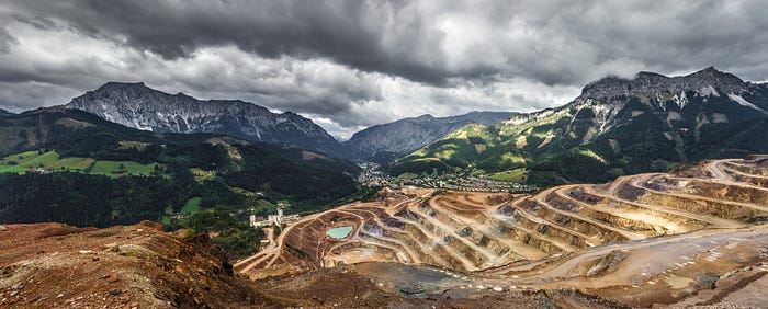 A strip-mining operation has created a stark contrast: dry, barren earth against the backdrop of lush and thriving rainforest.