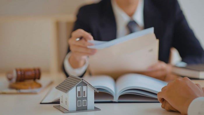 Real estate agent reviewing home purchase documents with a client at a Hilton Head Island agency.