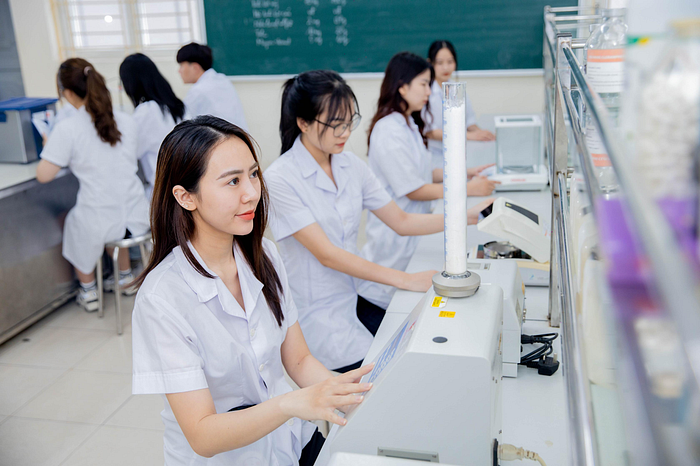 Các học sinh dược đang học với máy móc