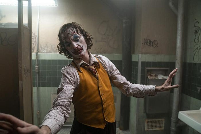 Joaquin Phoenix berdansa di dalam toilet menggunakan make up sebagai Joker