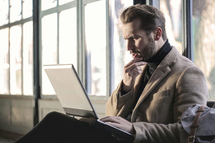 A man staring in disbelief at content on his laptop