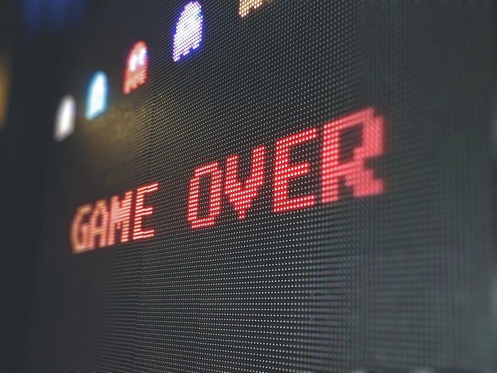 A colorful video game screen with text stating game over.