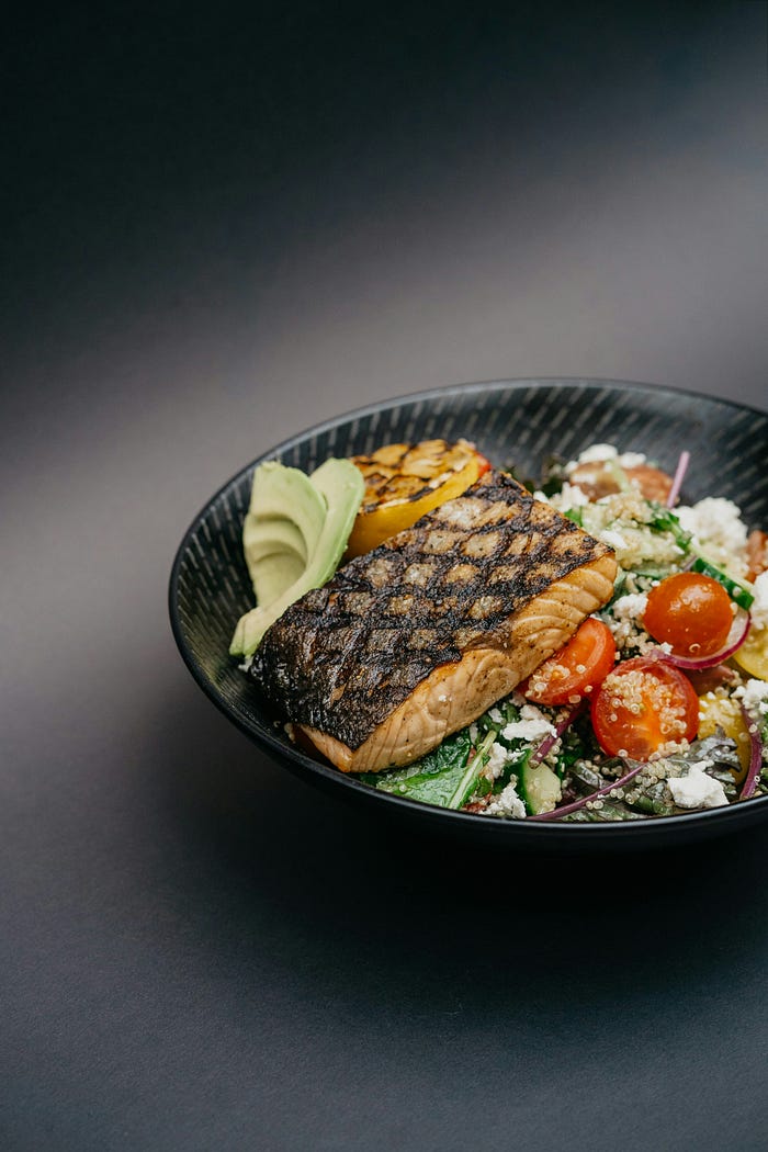Healthy salmon power bowl on a black background