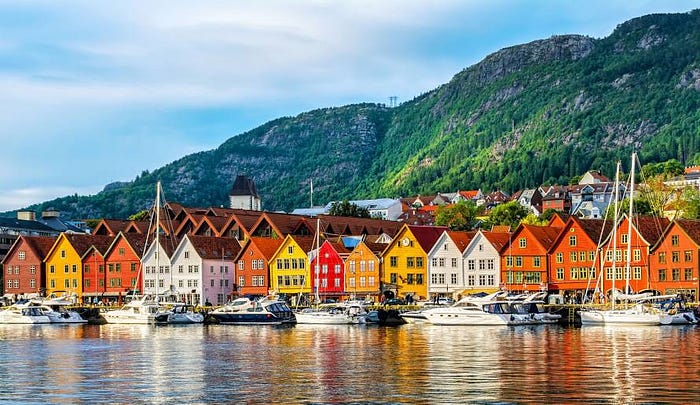 A picturesque photo of the historic Bryggen wharf in Bergen, Norway, with its iconic colorful wooden houses, setting the scene for a cultural heritage 3D modeling project.