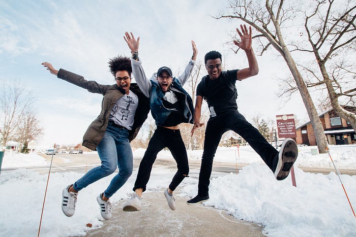 Three young people jumping in the air with arms and legs extended