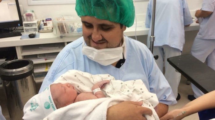 Alex segurando Nicolas, seu primogênito, pela primeira vez. (Ano: 2018/Acervo pessoal)