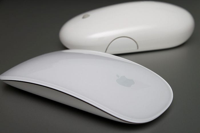 A magic mouse sits in front of a mighty mouse.