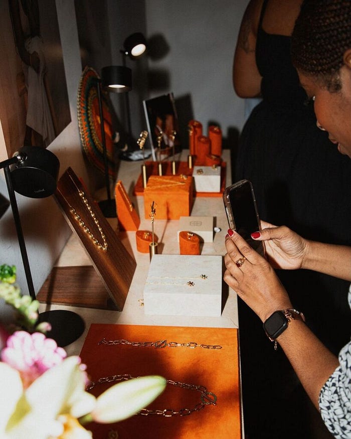 Attendee exploring new jewelry trends and photographing designer pieces at a jewelry exhibition booth – The Jewelry Gossips