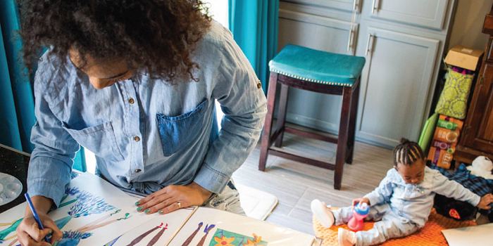 Woman working from home while caring for child