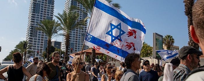 A woman holding an Israeli flag with bloodstains on it