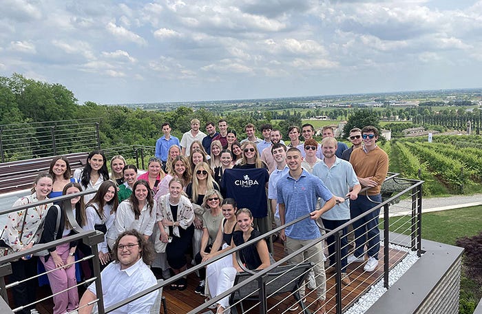 A group pose on a balcony overlooking the countryside. 
