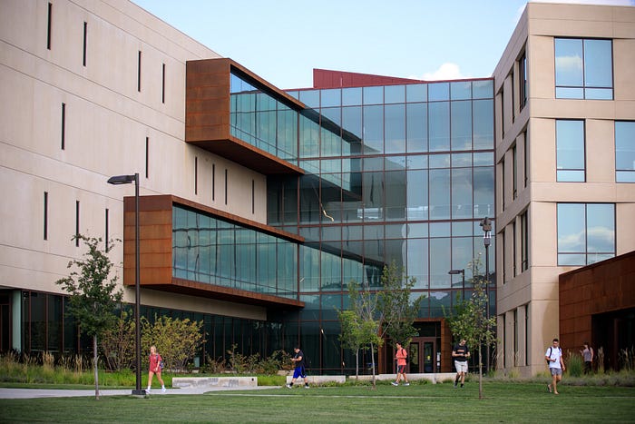 Exterior view of Capitol Federal Hall west entrance with students walking in front