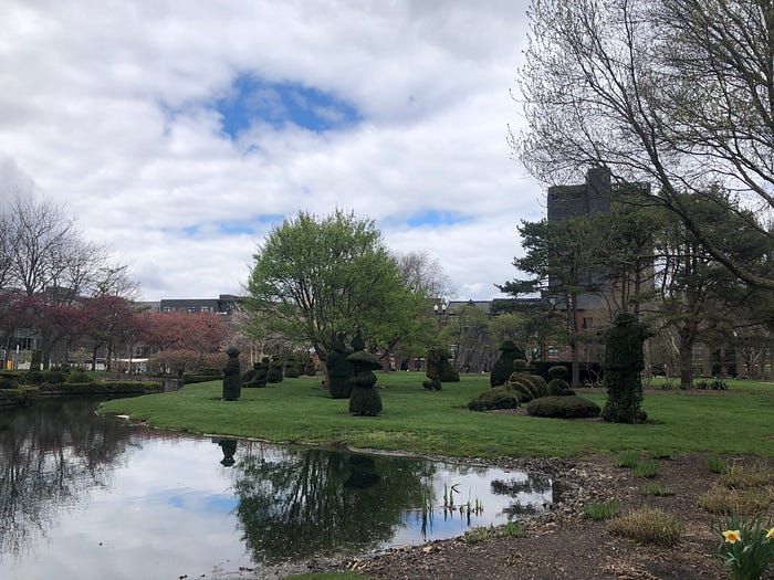 figures facing pond at Topiary Park