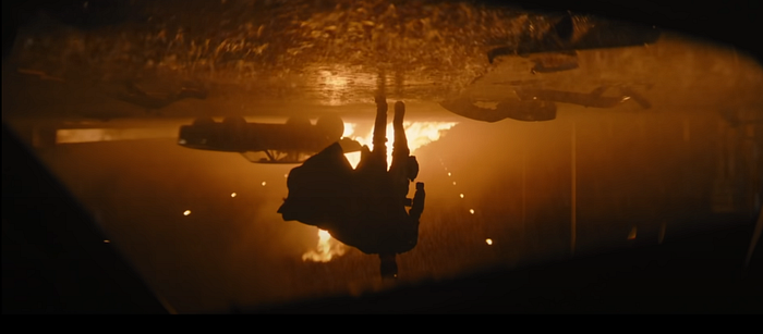 Batman berjalan menuju kita yang sedang berada di mobil yang sedang terbalik