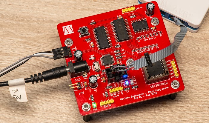 Photograph of a red-coloured electronic circuit board with cables attached.