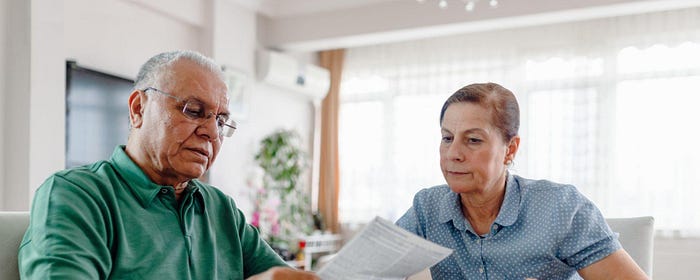 A man and woman looking at a bill