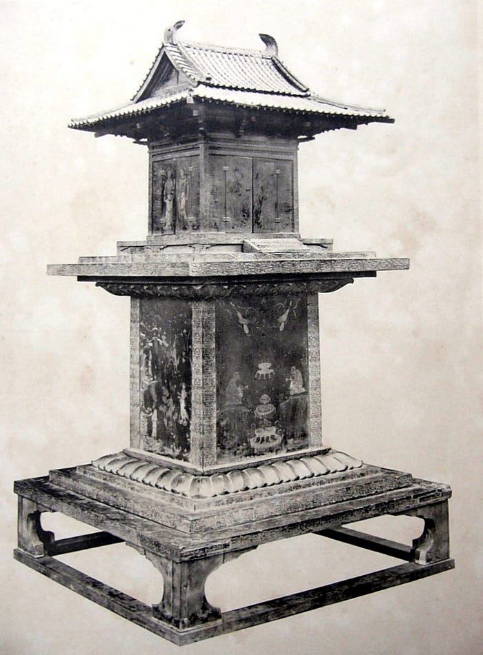 Black and white photo of pagoda shaped shrine with faint illustrations on the sides.