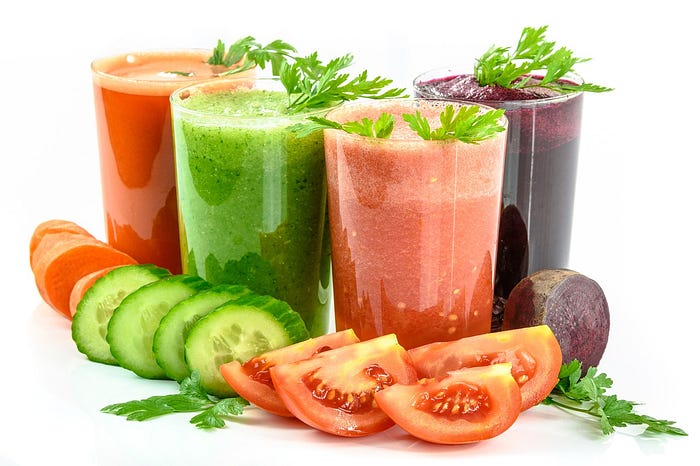 Picture of 4 vegetable smoothies with sliced veg at base