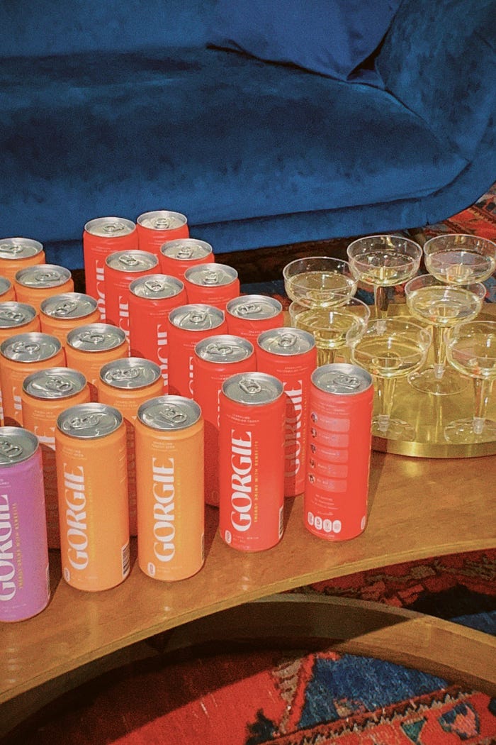 Group of GORIGE cans on a table with champagne glasses.