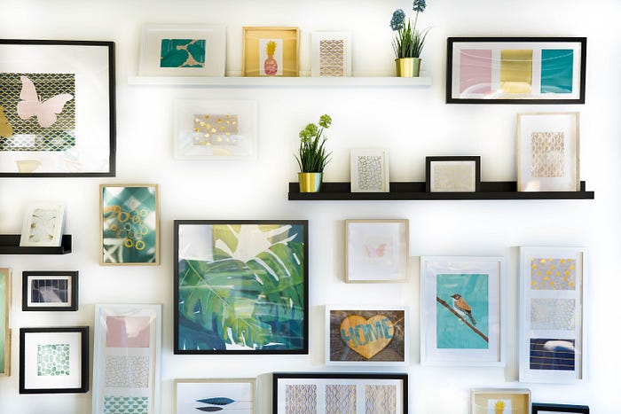 pictures and shelves of decorative objects arranged on a wall