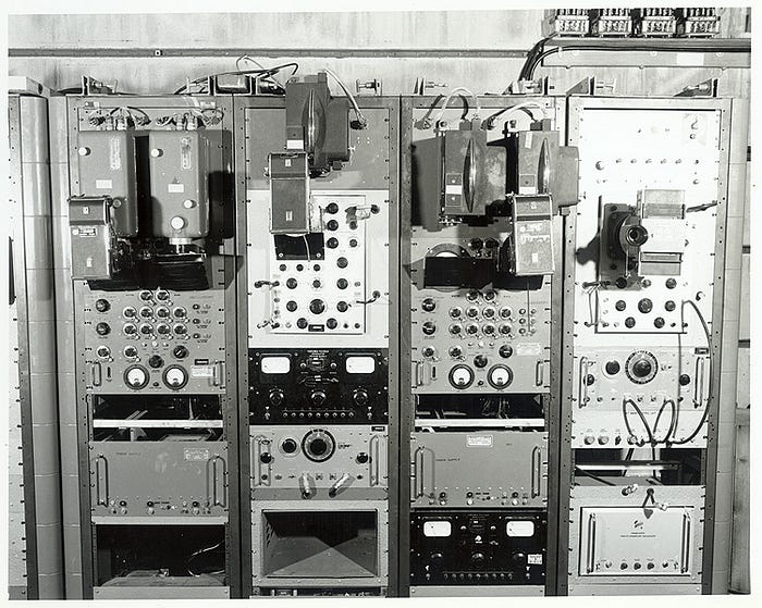 A black and white photo of four columns of old style mechanical equipment with knobs and readout windows. This was likely testing or monitoring equipment used at Bikini Atoll during the many nuclear tests that were conducted.