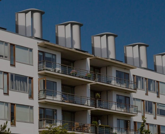 A view of a building complex adorned with Aeromine wind harvester units
