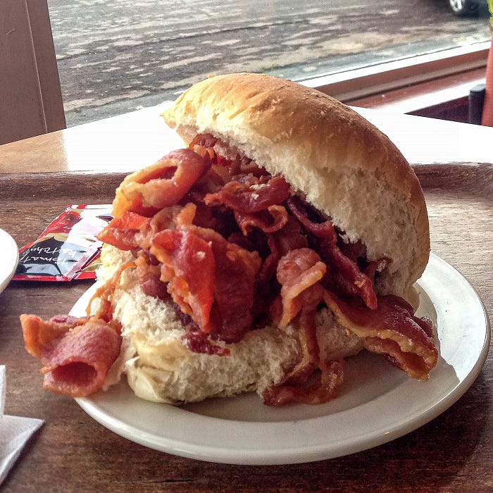 Photo of a bread roll stuffed full of crispy bacon. Image by Author.
