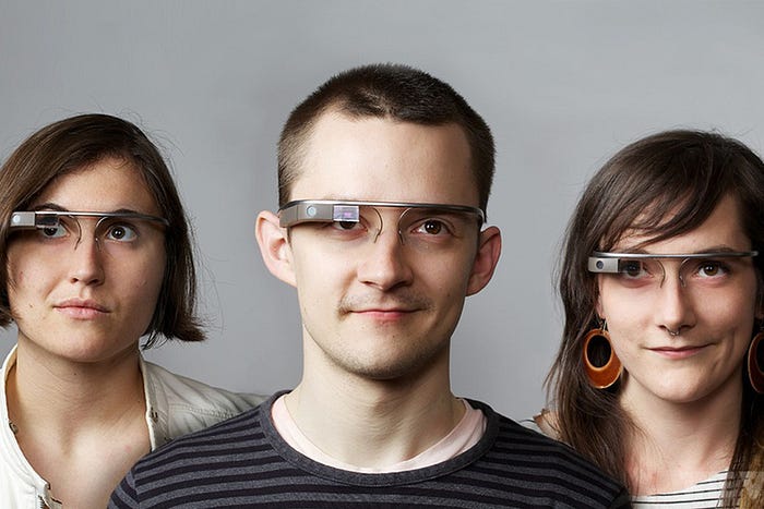 three people wearing Google Glass headsets