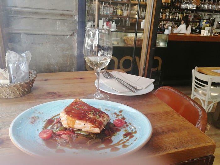 Salmon dish and white wine at a tapas bar in Seville, Spain