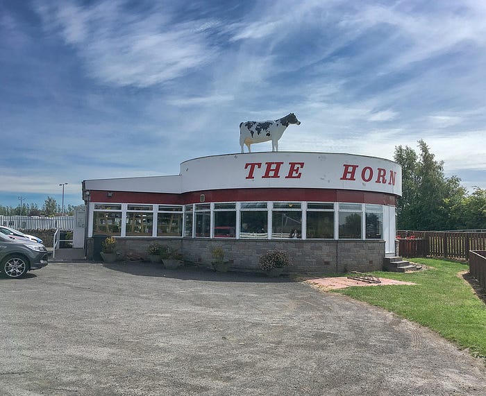 Photo of The Horn restaurant, with cow on top. Image by Author.
