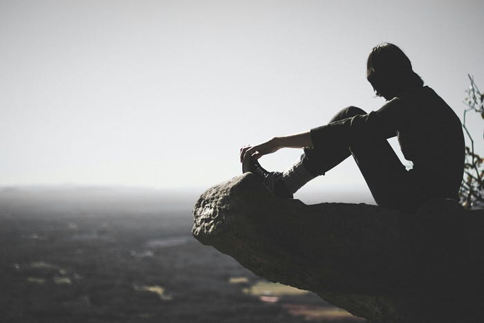 a person on a cliff top, getting rest.