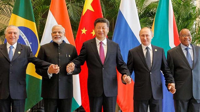 Photo of BRICS leaders holding each other hands to show their collaboration for a de-dollarization of the world economy